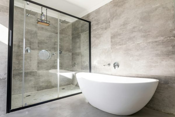 Empty bathtub by modern shower in bathroom at home